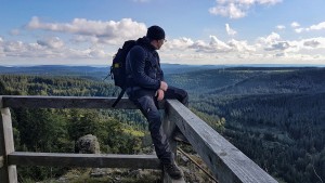 Hiker enjoys the view over wooded mountains