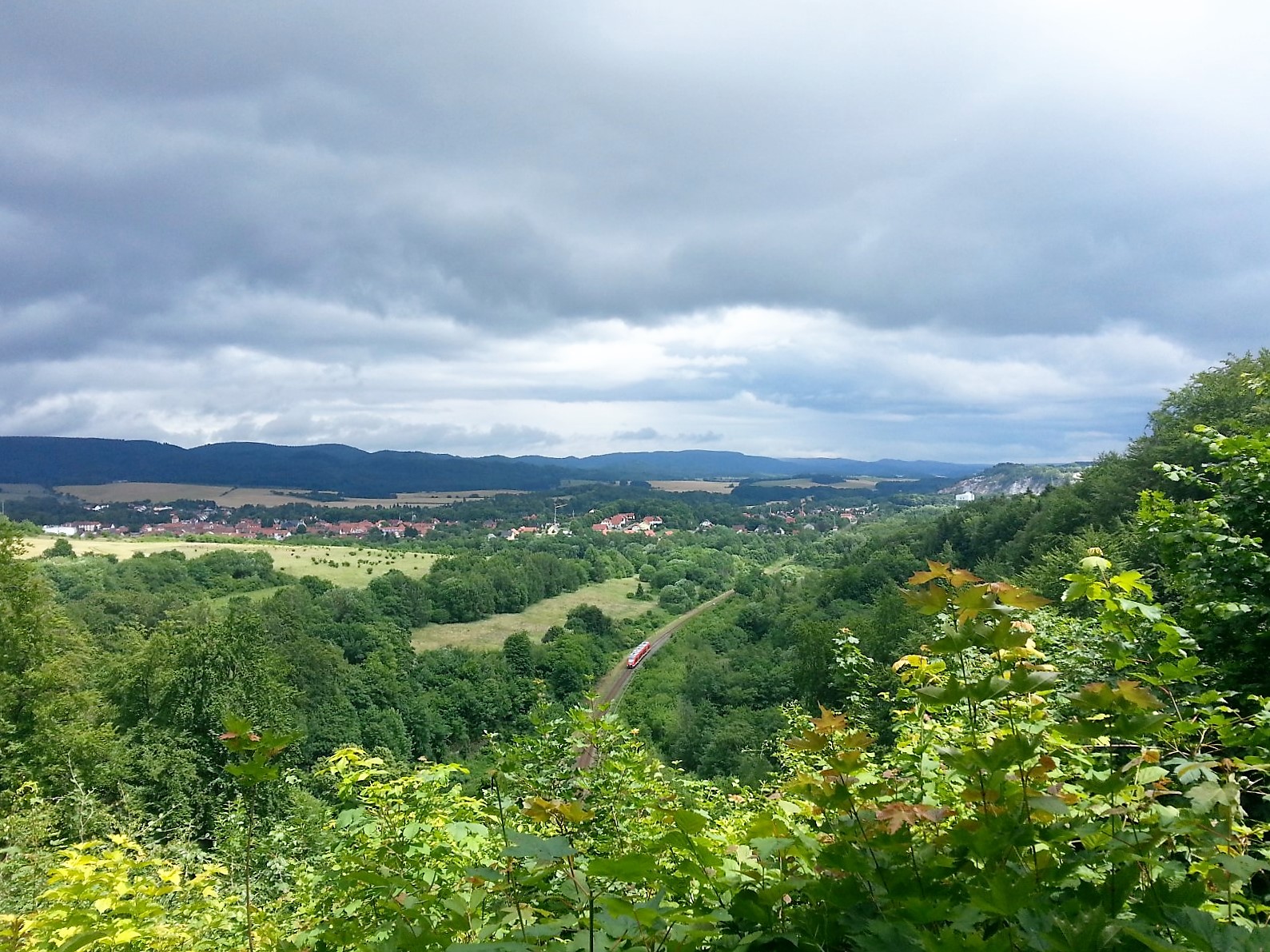 Landscape with valley, forests and village under a cloudy sky