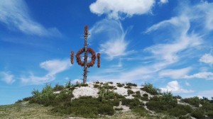 Wooden sculpture on a hill under a blue sky
