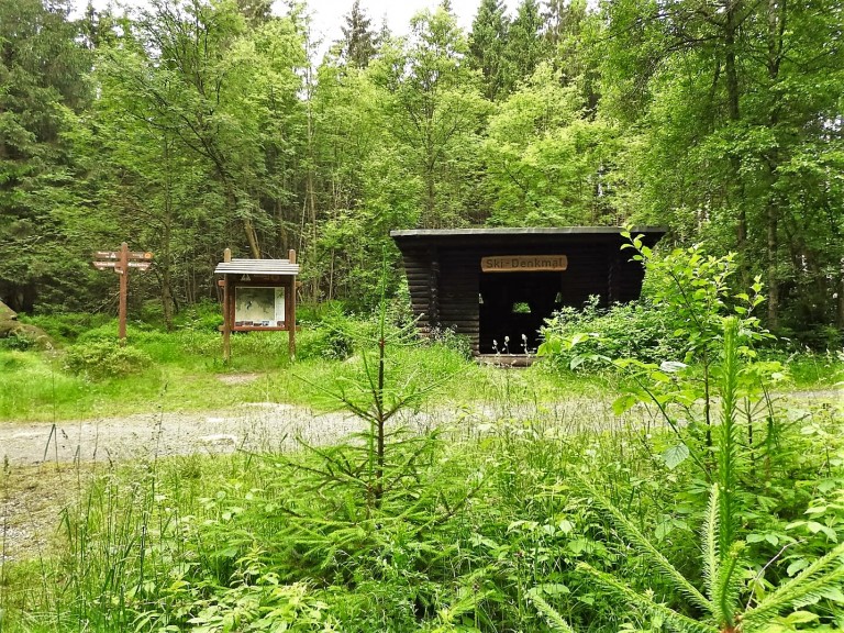 Waldhütte am Ski-Denkmal mit Wegweisern