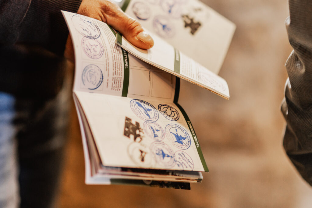 Hand hält Heft mit gesammelten Stempeln